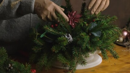 Wall Mural - Hands making Christmas table decoration. Xmas flower arrangement.