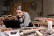 © SKW - Portrait of a female carpenter drawing on paper for designing and building furniture in a furniture factory. with modern tools