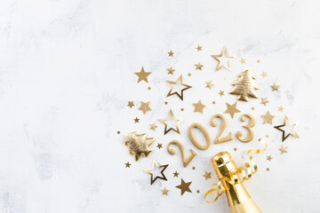 Christmas and New Year background with golden champagne bottle, party decorations, confetti stars and 2023 numbers.