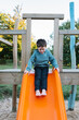© ADDICTIVE STOCK - Boy playing on slide in park