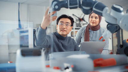 arabic female future engineer looks at work of skilful developer. asian man explains core principles