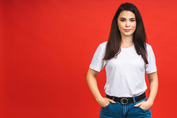 Wall Mural - Portrait of happy smiling brunette business girl woman in casual isolated over red background.