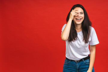 Wall Mural - Portrait of happy smiling brunette business girl woman in casual isolated over red background.