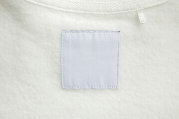 Wall Mural - Blank white laundry care clothes label on fabric texture background