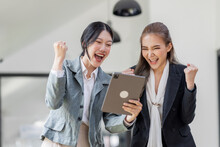 Pretty Two Asian Businesswoman Sitting On A Tablet  Laptop And The Work Came Out Successfully And The Goal Was Achieved, Excited Winners Or Happy People And Satisfied With Her.