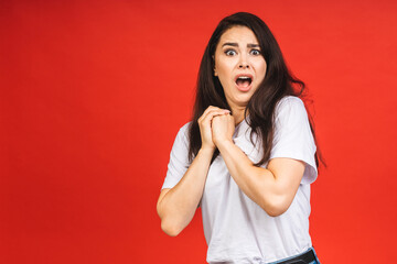 Wall Mural - OMG! Portrait of amazed shocked surprised young woman isolated over red background.