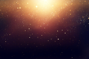 background of abstract glitter lights. gold and black. de focused