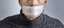 Man Silenced With Duct Tape Over His Mouth. Photo With Copy Space.