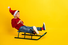 Full Body Photo Of Adorable Small Schoolboy Sled Have Fun Winter Vacation Stylish Red Knitted Clothes Isolated On Yellow Color Background