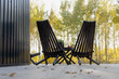 Two dark wooden chairs on the veranda. Landscape autumn. Horizontal