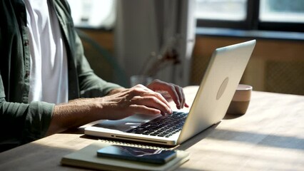 Wall Mural - Young man freelancer student using laptop studying online working from home in internet, smiling focused businessman typing on computer surfing web looking at screen enjoying distant job