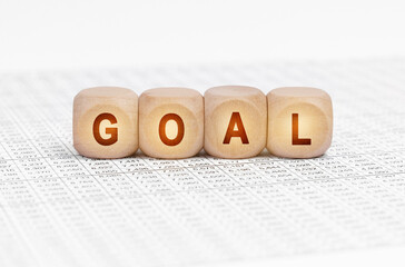 On the table with documents are wooden cubes with the inscription - GOAL