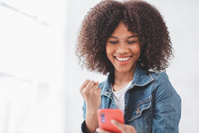 Excited African American Millennial  Female Hold Smartphone Happy Wining Online, Overjoyed Black  Female Look At Cellphone Smile Feel Joyful Reading Good News, Excited Afro Female Yells