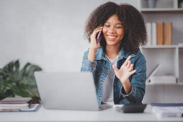 Young businesswoman cheerful african american lady working at workplace office, Afro female work with laptop financial documents having phone conversation, copy space	