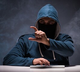 Computer hacker working in dark room