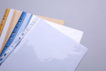 Wall Mural - File folders with punched pockets and paper sheets on light grey background, above view