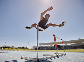 Running, jump and athlete hurdle for a speed exercise, marathon or runner training in a stadium. Short health, cardio and man run fast for a jumping competition or fitness workout for sports wellness