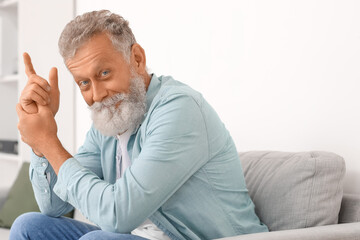 Sticker - Senior bearded man sitting on sofa at home