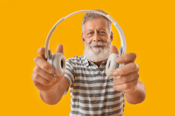 Poster - Senior bearded man with headphones on yellow background