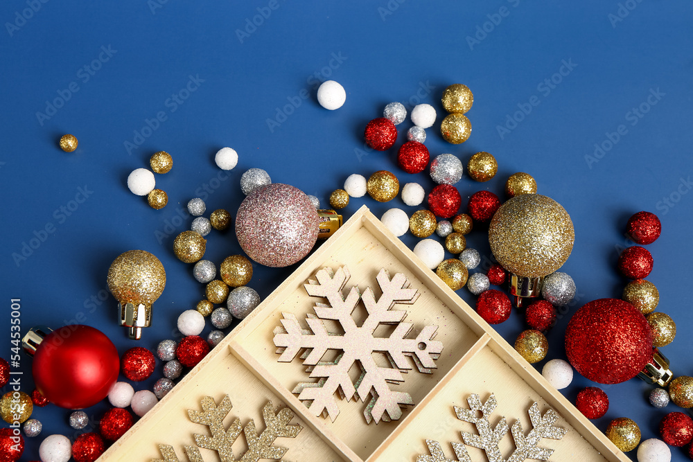 Wooden box with beautiful Christmas decorations on blue background, closeup