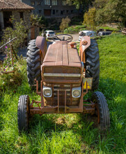Beautifully Lit Restored Antique Tractor Parked In A Rural Field With Green Grass In Front View