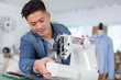handsome fashion designer sewing with a sewing machine