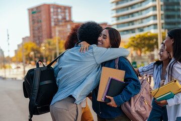 Cheerful students hugging at university.