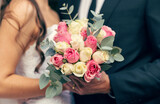 Fototapeta Morze - Flowers, wedding and love with a bouquet in the hands of a bride and groom on their marriage day closeup. Rose, married and celebration event with a floral arrangement in hand during a ceremony