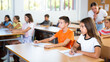 © JackF - Boy and girl sitting at desk in classroom and studying during lesson in school.