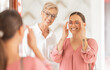 © Alexis S/peopleimages.com - Mirror, glasses and optician with woman and doctor for consulting, vision and eye care. Retail, shopping and insurance with consultant and customer in store for healthcare, optometry or medical