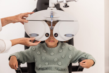 Canvas Print - Girl, Ophthalmologist and eye test in an exam in clinic for medical check. Female optician or optometrist expert checking vision of a child examination equipment inside an optometry room at hospital