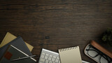 Fototapeta Kawa jest smaczna - Top view of eyeglasses, keyboard, pen and notepad on wooden working desk. Simple workplace