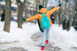 © deagreez - Rear back behind view of preteen girl wearing warm clothes dancing having fun wintertime snowy weather outdoors