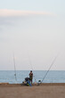 © MiguelAngel - fisherman fishing on the shore of the beach