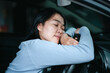 © natara - Young asian woman sleepy tired close eyes driving her car after long hour drive.