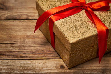 Gift present birthday Christmas concept - gift box with red ribbon on wooden background close up