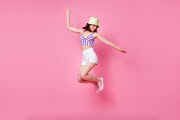 Wall Mural - Full size photo of cheerful lady tourist jumping high hands aside isolated pastel color background