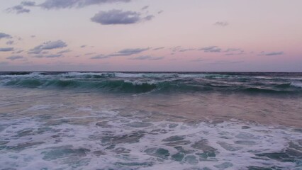 Wall Mural - Seaside sunset with foamy waves crashing at the shore