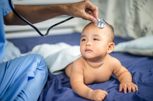 Asian Doctor Examining Little Baby With Stethoscope In Clinic. Baby Health Concept