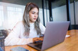 © EduLife Photos - Teenage Asian girl student studying online on a laptop writing notebook in a private studying room