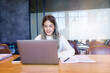 © EduLife Photos - Teenage Asian girl student studying online on a laptop writing notebook in a private studying room
