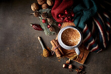 Hot Milk With Christmas Spices, Warm Shawl And Christmas Decorations On Rustic Background. Copy Space