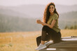 © BGStock72 - Young woman relaxing on a terrain vehicle hood at countryside