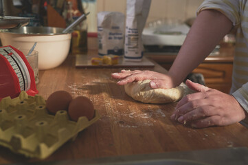 Woman kneads the dough to improve fermentation and generate gluten that gives it elasticity. Homemade preparation of dough with wheat flour to make bread, pizza or empanadas.