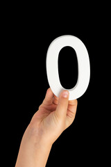 Fototapete - Zero in hand. The number zero is clasped in a hand isolated on a black background. Number zero white in a child's hand on a black background.