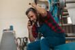© DusanJelicic - A young serviceman on work breaks sits on a machine and talks on the phone.