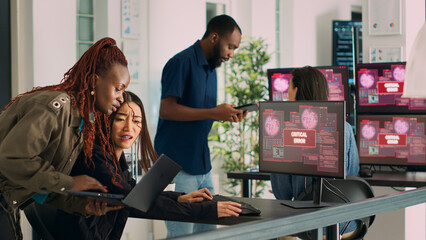 Wall Mural - diverse group of engineers having computer hacked and system crash on multiple monitors, reading cri