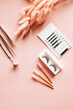 Tools for eyelash extension on trendy pastel pink background. False eyelashes, tweezers and brushes. Beauty shop. Makeup cosmetics. Top view, flat lay