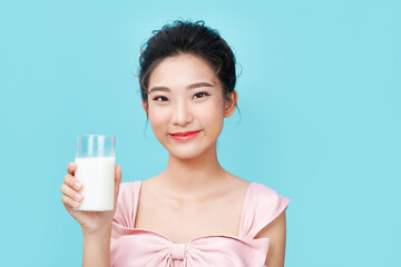 Canvas Print - Beautiful young woman with glass of milk over cyan background