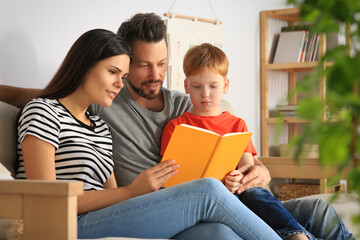 Sticker - Happy family reading book together on sofa in living room at home